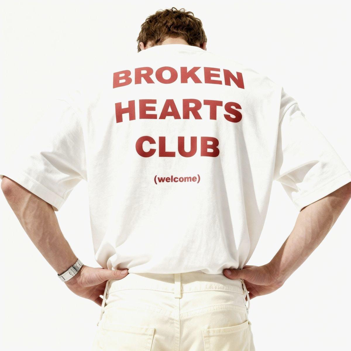 Off white relaxed tee worn back to camera with red Broken Hearts Club type